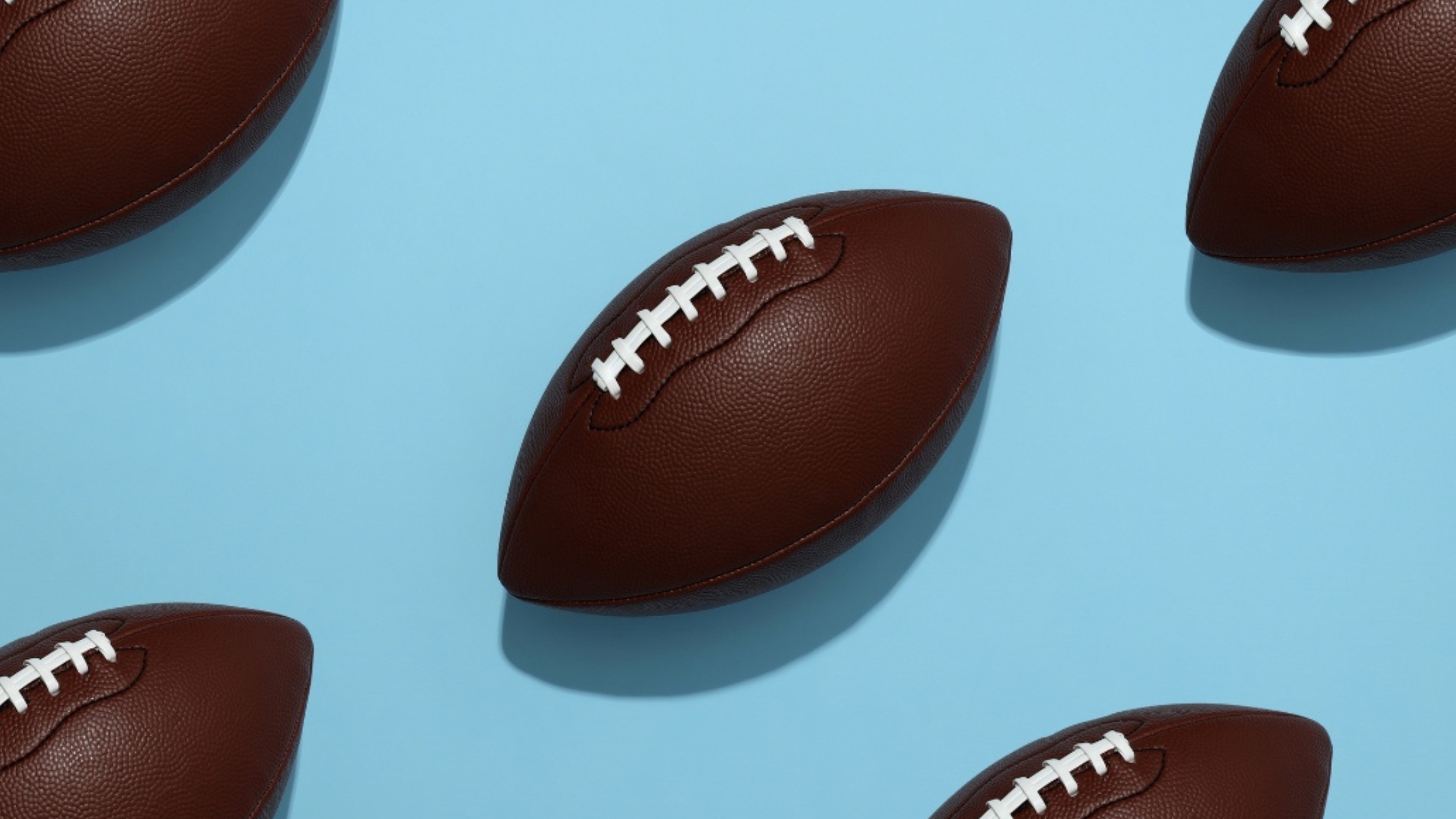 Multiple footballs on a blue background.