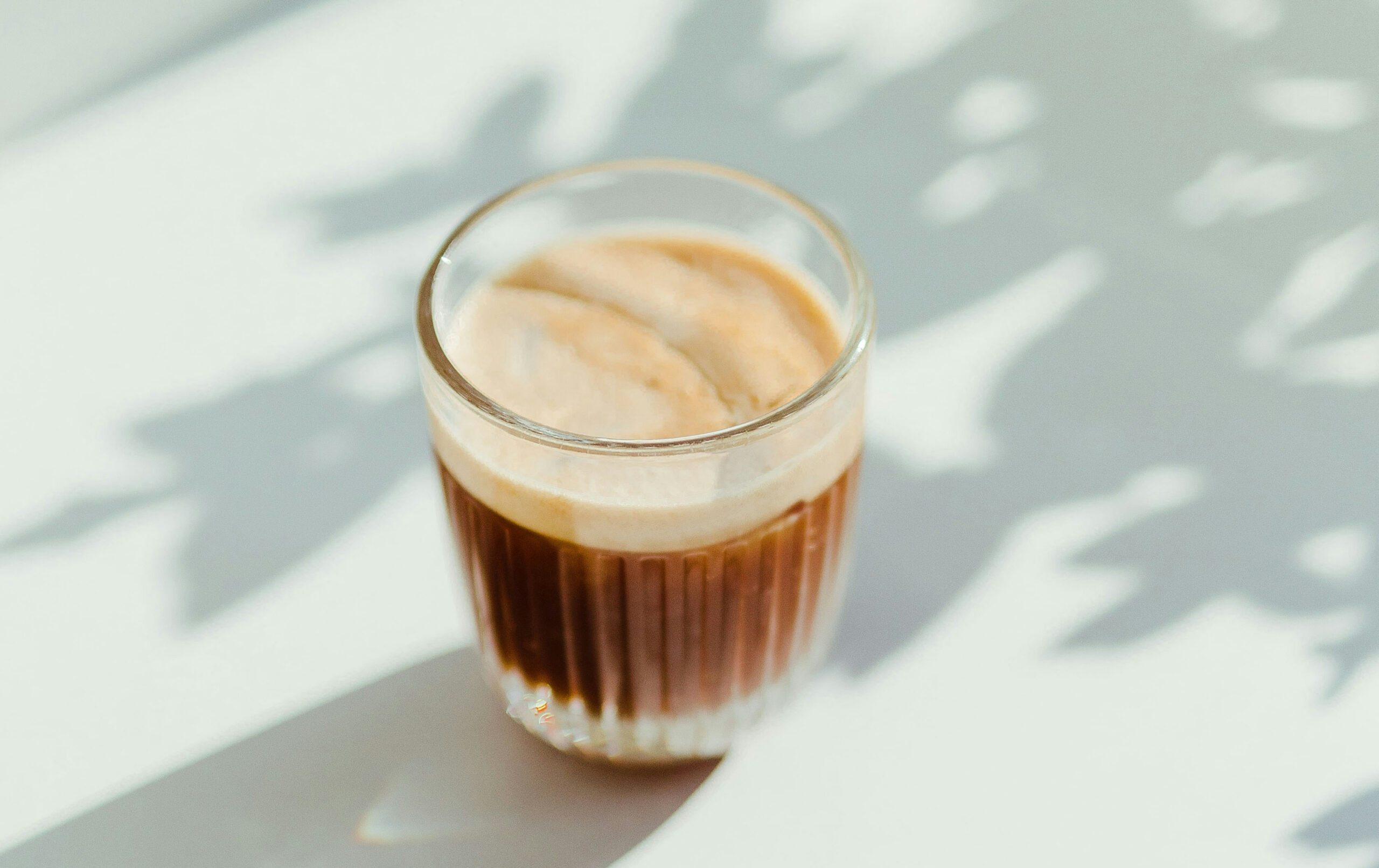 A cortado served in a small glass.